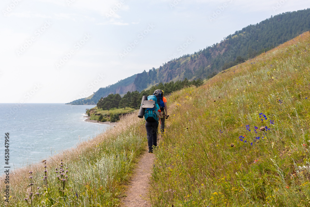 tourists walk along the shore of Lake Baikal