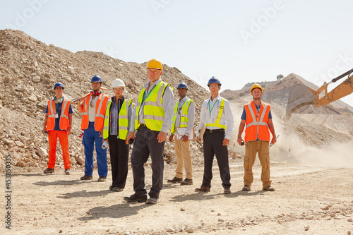 Businessman watching workers in quarry