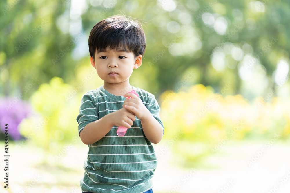 Happy Asian little boy playing with soap bubbles outdoor in the park. Smiling Toddler little boy having fun, enjoy, relaxing with soap bubbles. Kid, play, field trips and education concept Happy Asian little boy playing with soap bubbles outdoor in the park. Smiling Toddler little boy having fun, enjoy, relaxing with soap bubbles. Kid, play, field trips and education concept