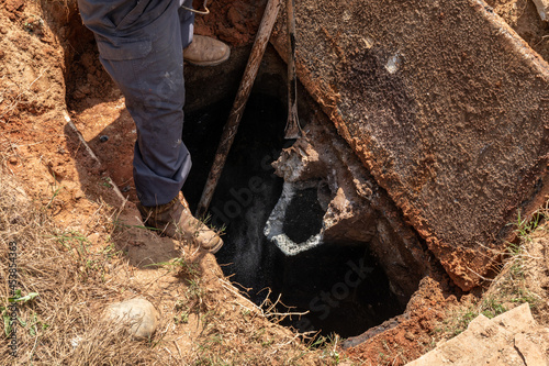 Old concrete chipped away in a septic tank being pumped and updated, horizontal aspect photo