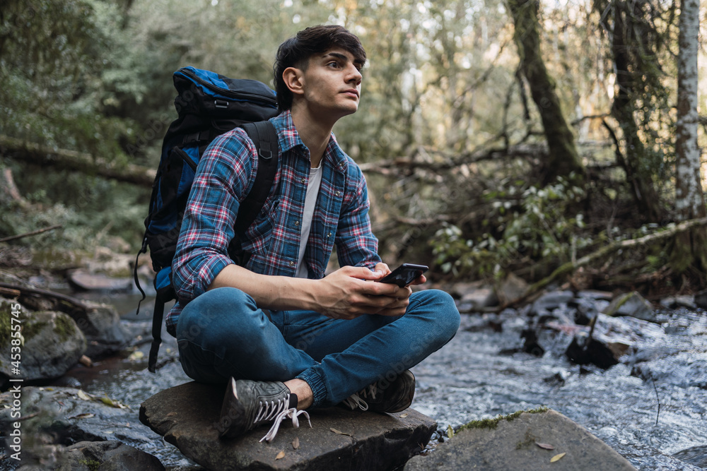 Smiling traveling man using smartphone during hike Smiling traveling man using smartphone during hike