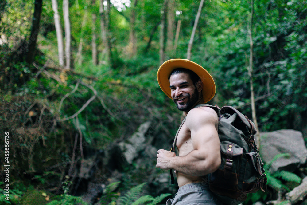 Traveling man with naked torso and backpack in forest Traveling man with naked torso and backpack in forest