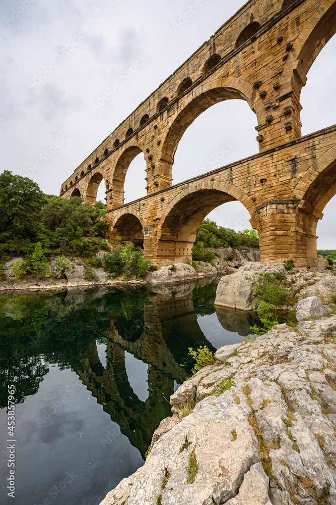 Low angle view of a Roman Empire aqueduct, Pont du Gard in France. Ancient civilisation engineering for water supply.