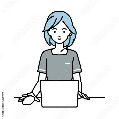 デスクで座ってPCを使っているエステ店員の女性