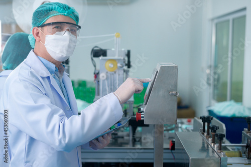 Workers producing surgical mask in modern factory  Covid-19 protection and medical concept.