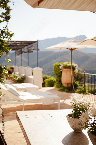 Lounge chairs and umbrellas on balcony of luxury hotel © KOTO