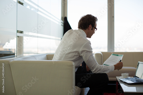 Businessman sitting on sofa in office lobby