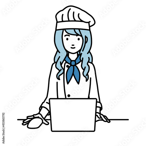 デスクで座ってPCを使っている調理師の女性