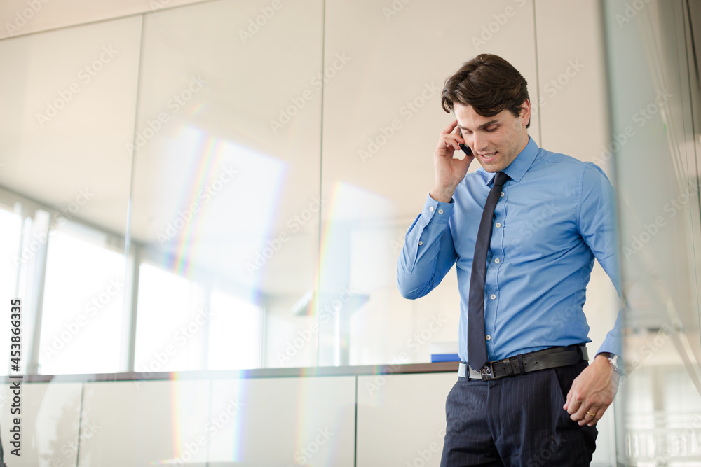Businessman talking on cell phone in office