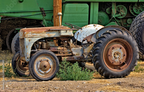 A worn, rusted tractor has been retired in this farm lot.