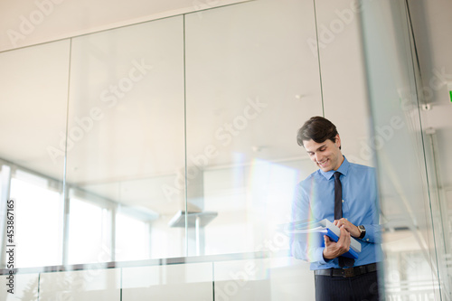 Businessman standing in office hallway