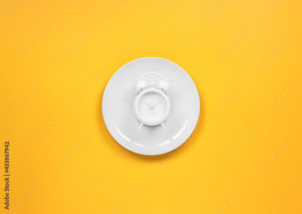 alarm clock on a dish with fork and knife alarm clock on a dish with fork and knife