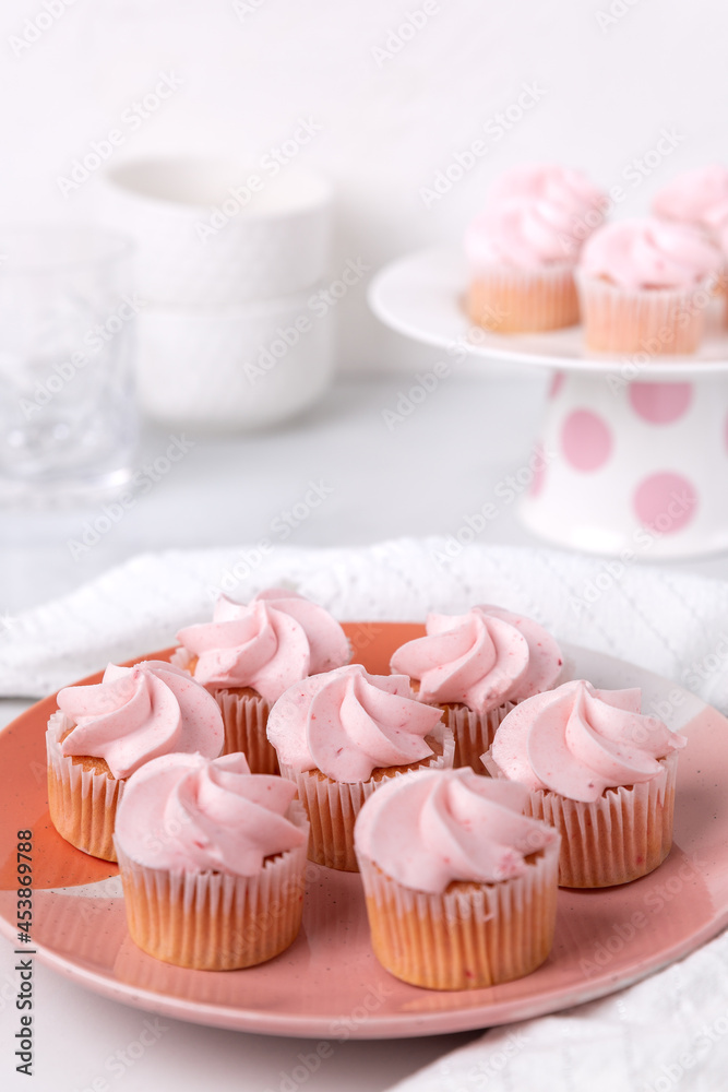 A plate of pink mini cupcakes in a white kitchen setting