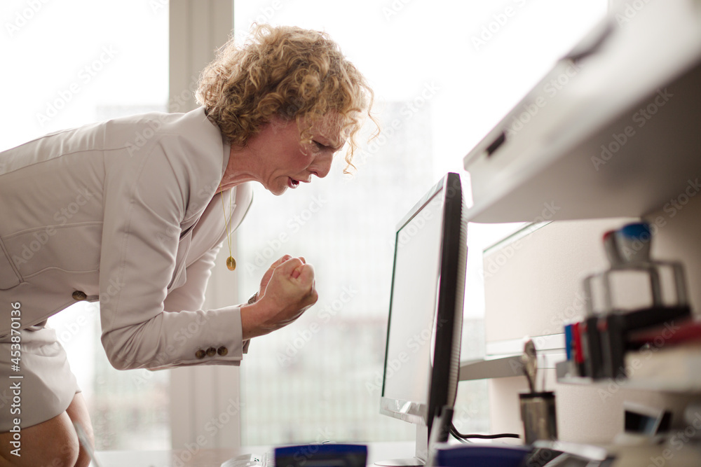 Businesswoman yelling at computer in office
