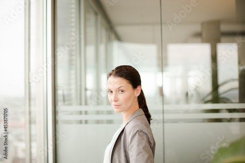 Businesswoman standing at office window Free Download Businesswoman standing at office window - GFXLoad