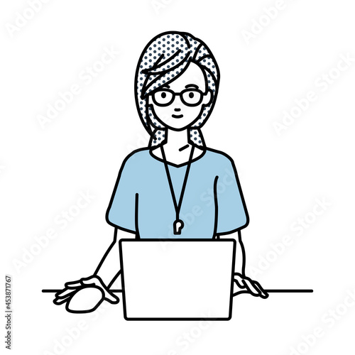 デスクで座ってPCを使っている教師の女性