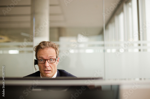 Businessman talking on headset in office