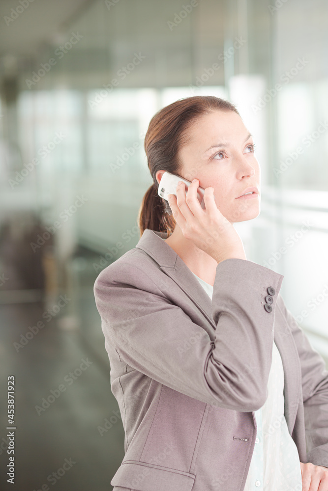 Businesswoman talking on cell phone in office Businesswoman talking on cell phone in office
