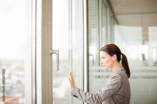 Free Download Businesswoman standing at office window - GFXLoad