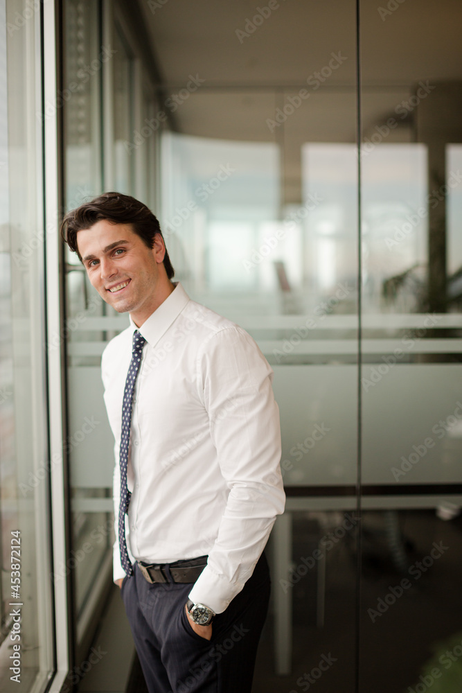Businessman standing at office window Businessman standing at office window