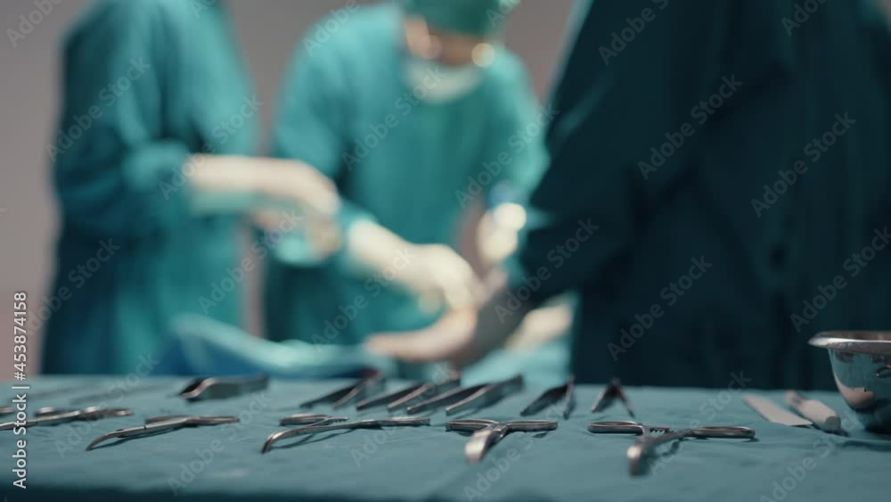 Young Asian assistants and nurses performing invasive surgery on patient in hospital operating room. Diverse team of professional surgeon, Healthcare and medical concept.