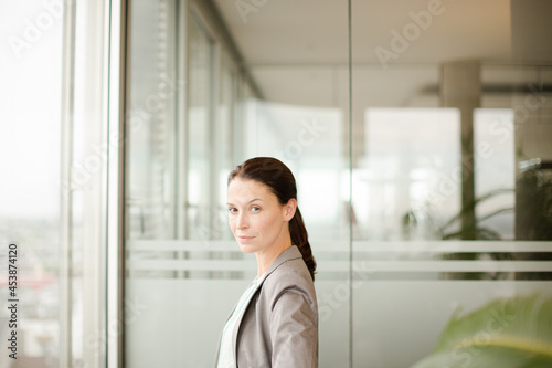 Free Download Businesswoman standing at office window - GFXLoad
