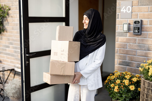 Muslim woman carrying parcels home photo
