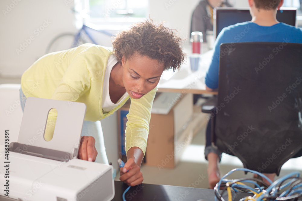 Obraz premium Businesswoman using printer at desk