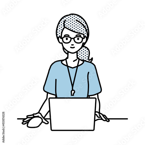 デスクで座ってPCを使っている教師の女性