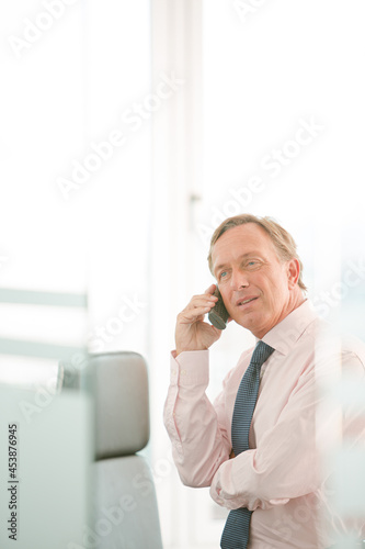 Businessman using cell phone in office