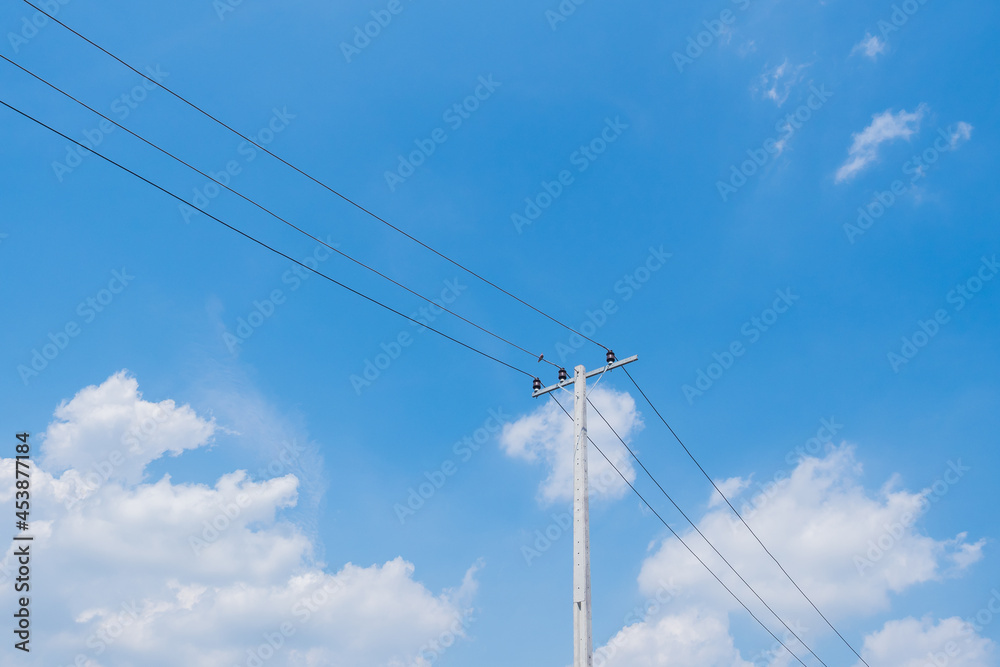 Electric pole and cable line with white clouds and blue bright sky background Electric pole and cable line with white clouds and blue bright sky background