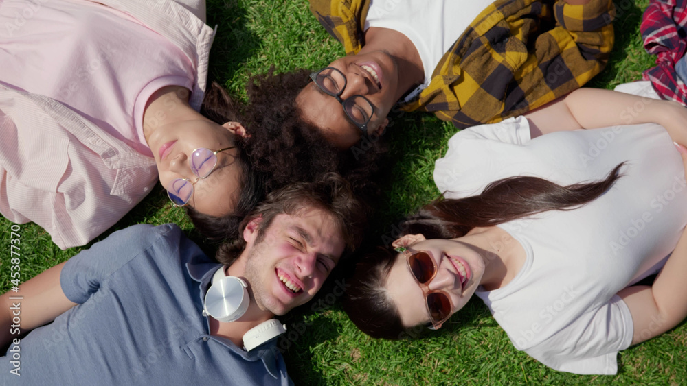 Top view of diverse students lying on grass and smiling Top view of diverse students lying on grass and smiling