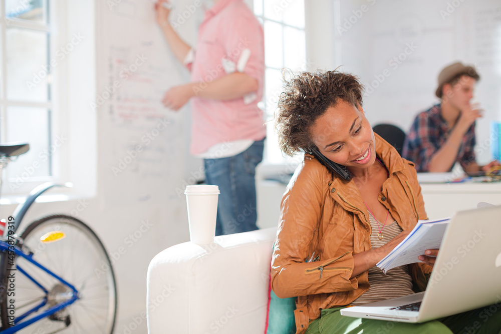 Obraz premium Businesswoman taking notes on phone in office