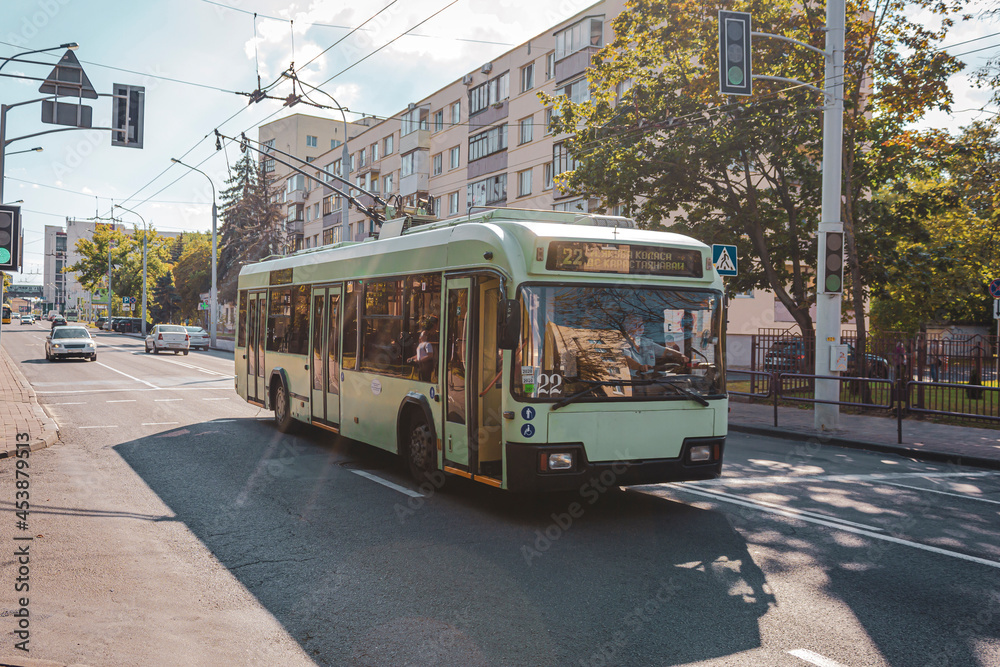 Naklejka premium A trolleybus rides along a summer street in Minsk