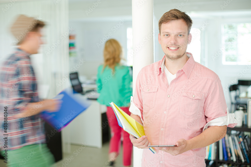 Fototapeta premium Businessman carrying folders in office
