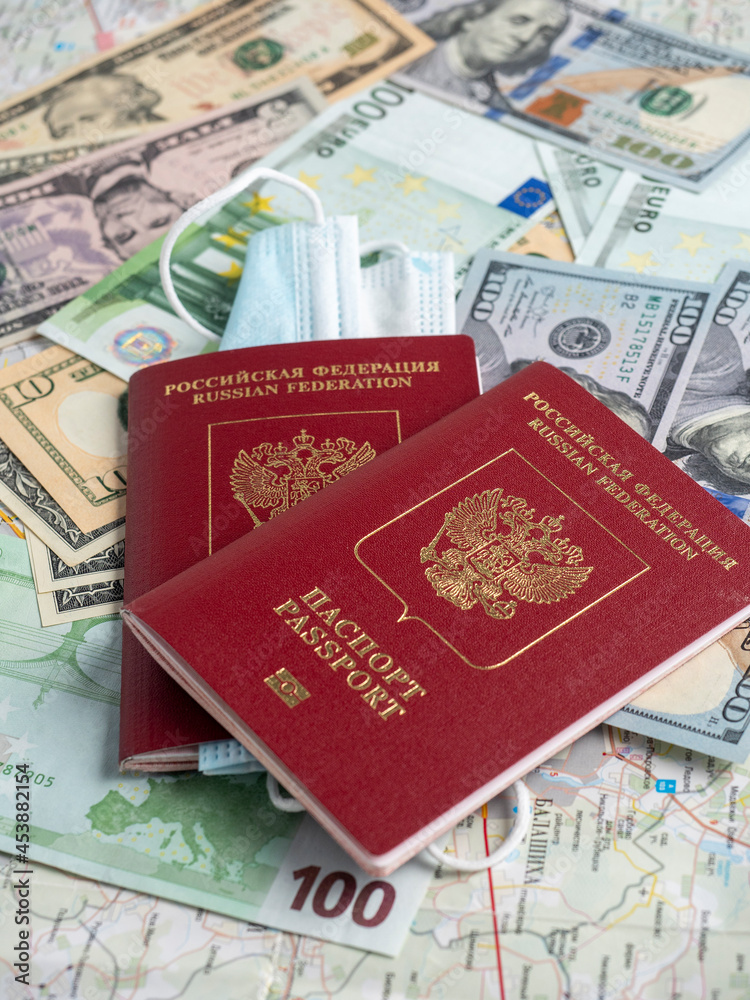 A close-up of a Russian passport with embedded dollar bills is on the map. The concept of travel and recreation.. Side view A close-up of a Russian passport with embedded dollar bills is on the map. The concept of travel and recreation.. Side view