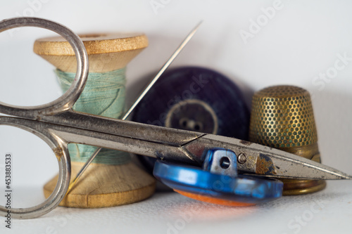 Closeup shot of a set of tailor's tools with timble, scissors and thread with buttons photo