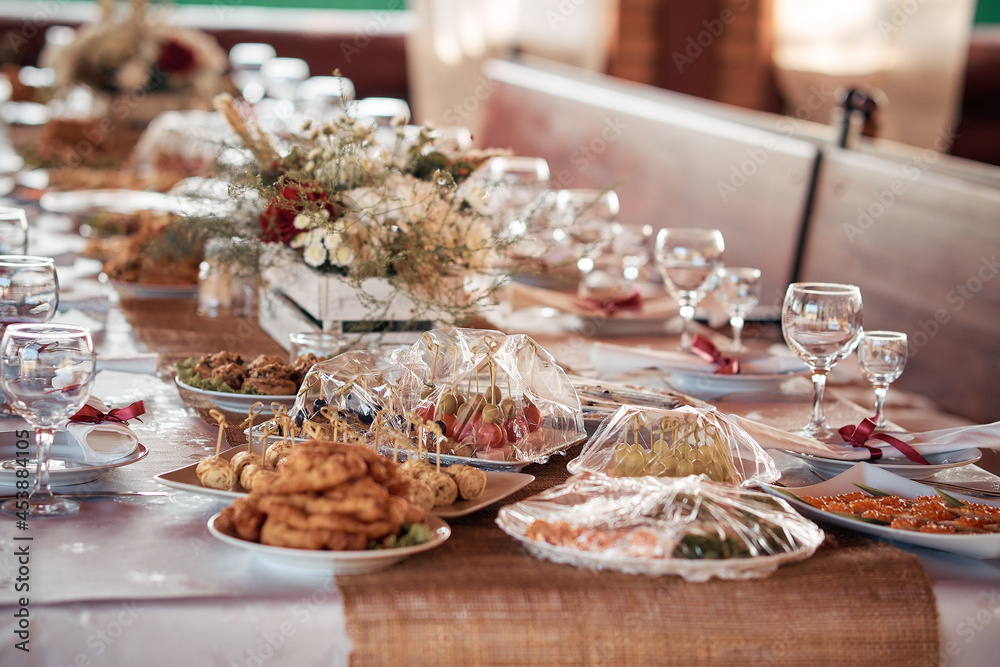 Decorated elegant wooden wedding table for banquet outdoor in garden gazebo