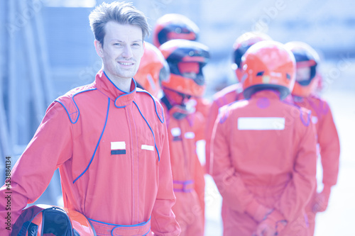 Racer holding helmet on track