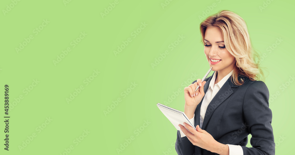 Businesswoman with notepad writing, isolated over light green color background. Business success concept. Copy space empty area for some text message or slogan. Businesswoman with notepad writing, isolated over light green color background. Business success concept. Copy space empty area for some text message or slogan.