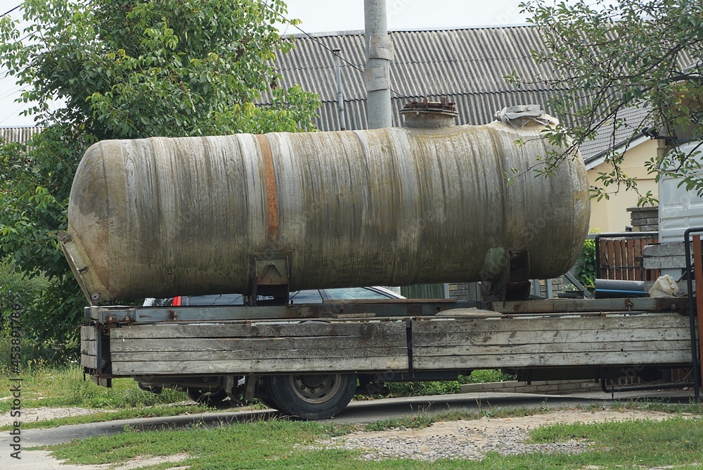 one gray large iron tank on a trailer with truck wheels on the street one gray large iron tank on a trailer with truck wheels on the street