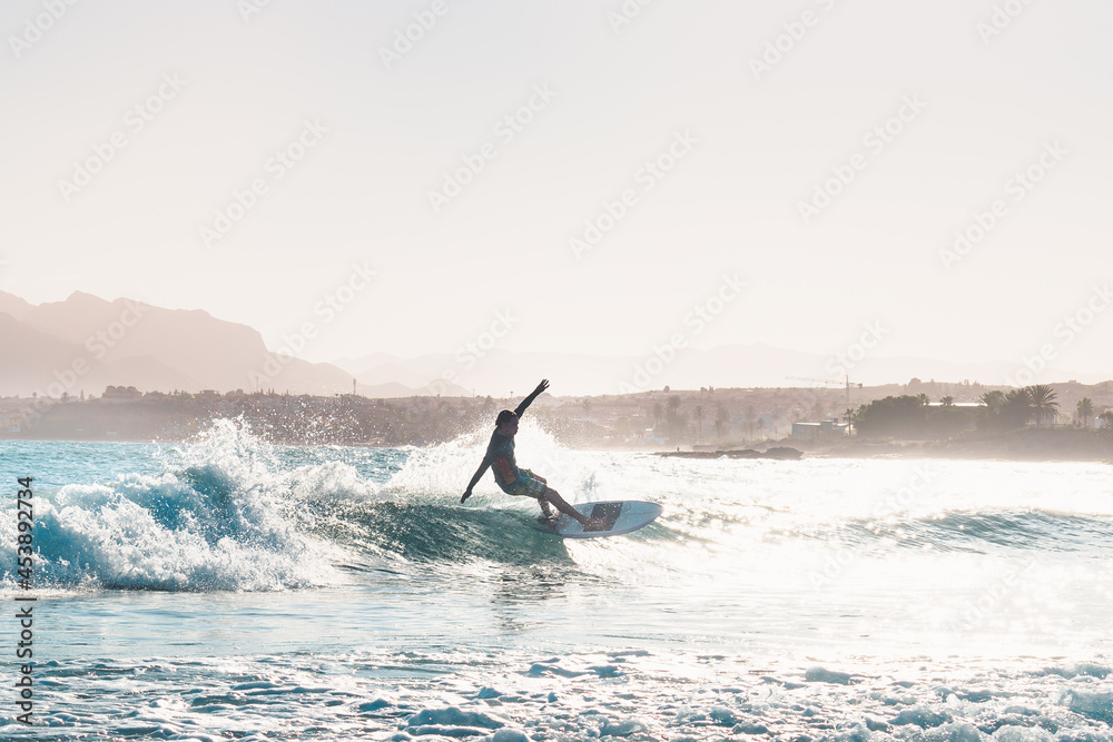 Fototapeta premium young male surfer riding a wave in the afternoon