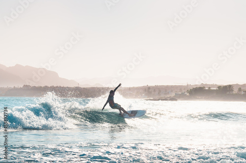 young male surfer riding a wave in the afternoon