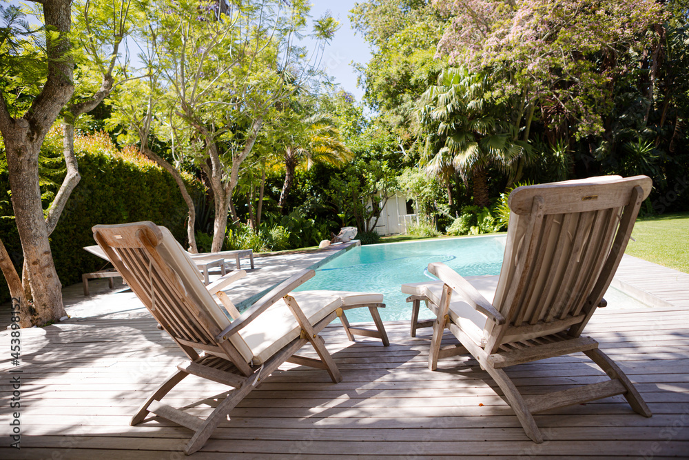 Lawn chairs and swimming pool in backyard Lawn chairs and swimming pool in backyard