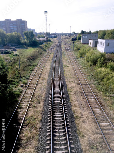 Railway tracks in the summer , in the city limits,stretching into the distance. Top view.