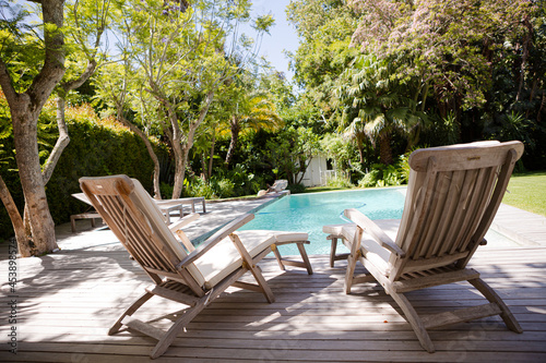 Lawn chairs and swimming pool in backyard © KOTO