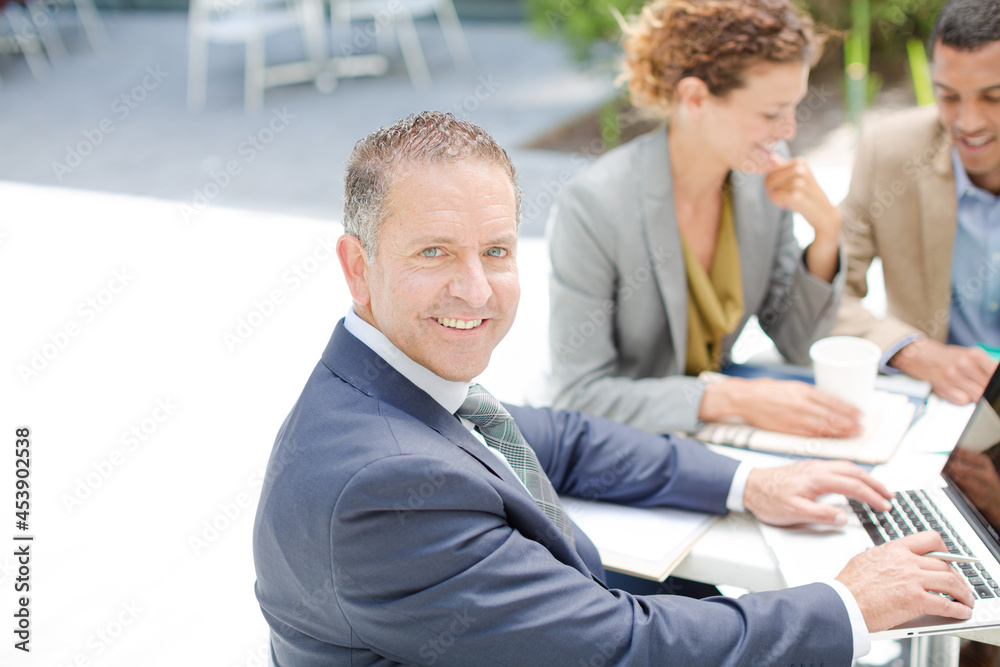 Fototapeta premium Businessman smiling in meeting outdoors