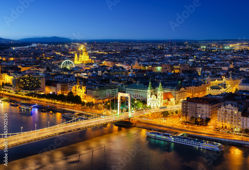 View of Budapest at night, Hungary. A cityscape in Europe. Ferris wheel and ancient architecture. Bridges and the Danube River. Landscape from above.