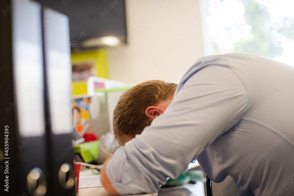 Businessman resting head on desk Businessman resting head on desk