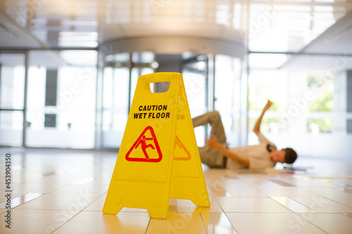 Businessman slipping on wet office floor